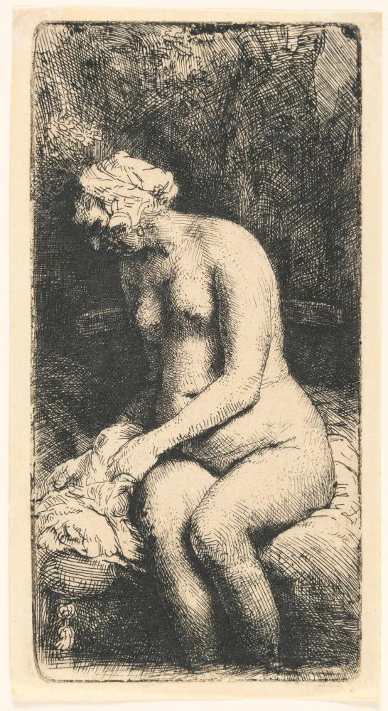 Sitzende Frau mit den Füssen im Wasser